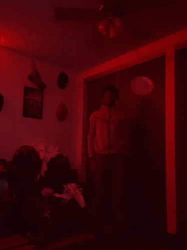 Man in Red Jacket Dark Room Ceiling Fan