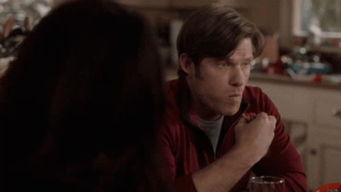 Man in Red Jacket Eating Pizza