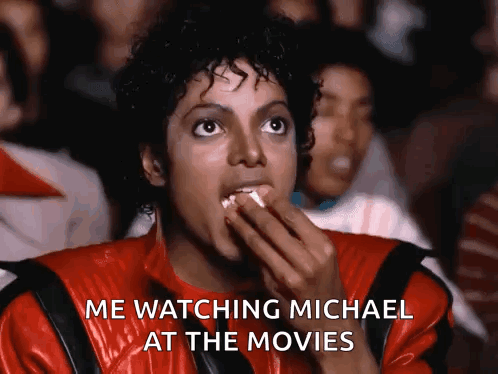 Man In Red Jacket Eating Popcorn Says Me Watching Michael At The Movies GIF