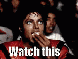 Man in Red Jacket Eating Popcorn Watching Movie