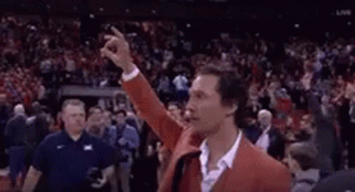 Man in Red Jacket Giving Middle Finger to Crowd in Stadium
