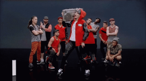 Man in Red Jacket Holding Boombox in Crowd