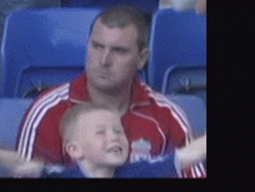 Man in Red Jacket Holding Boy in Blue