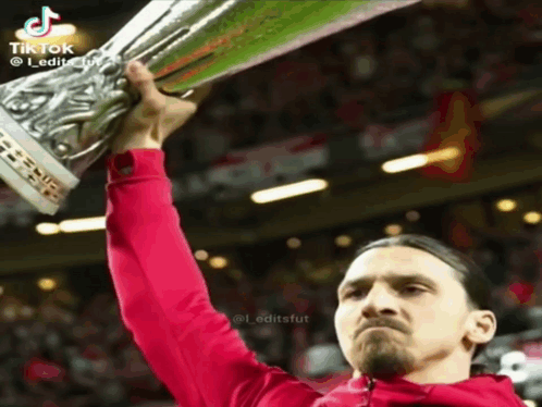Man in Red Jacket Holding Trophy