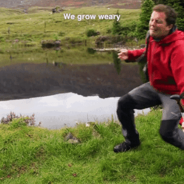 Man In Red Jacket Kneeling Near Lake GIF