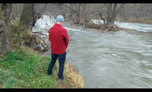 Man in Red Jacket Looking at River