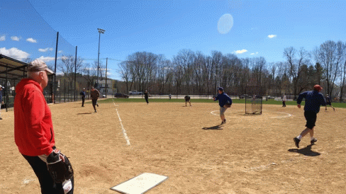 Man in Red Jacket on Baseball Field