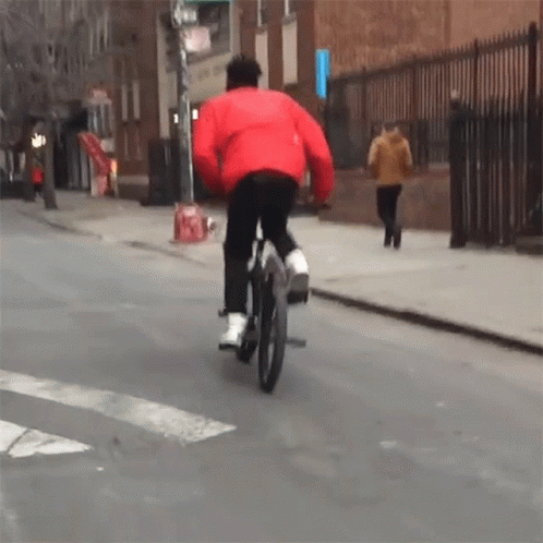 Man in Red Jacket Riding Bicycle