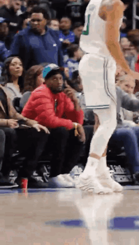 Man in Red Jacket Sitting at Basketball Game