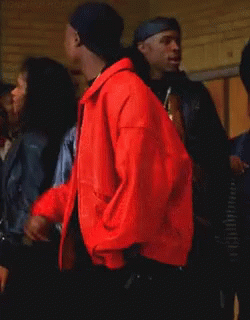 Man in Red Jacket Smoking Cigarette in Crowd