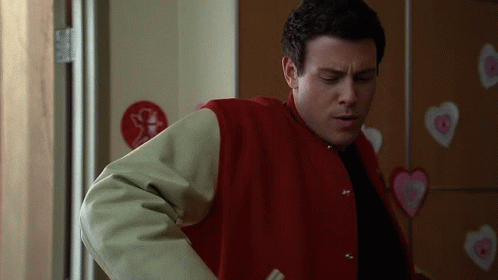 Man in Red Jacket Standing Before Heart Wall