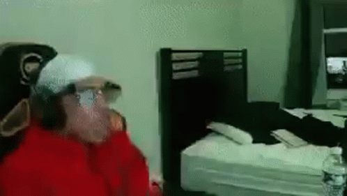 Man in Red Jacket Standing in Bedroom