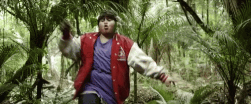 Man In Red Jacket Standing In Jungle GIF