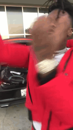 Man In Red Jacket With Hands Up By Car GIF