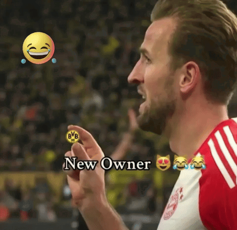 Man in Red Jersey Holding BVB Coin