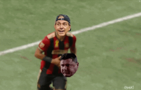 Man in Red Jersey Number 4 Running on Soccer Field