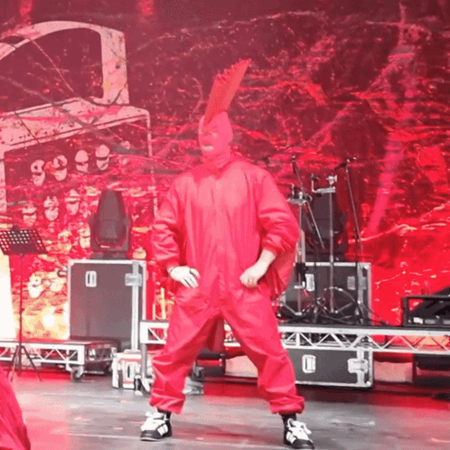 Man in Red Jumpsuit Dancing with Drum Set