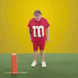 Man In Red M&Ms Shirt Dancing On Field GIF