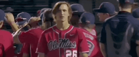 Man in Red Ole Miss Baseball Jersey Standing in Front of Crowd
