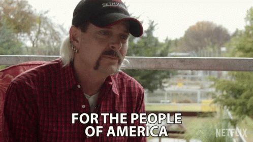 Man in Red Plaid Shirt and Hat Says For the People of America