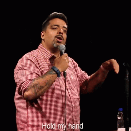 Man in Red Plaid Shirt Holding Microphone Saying Hold My Hand