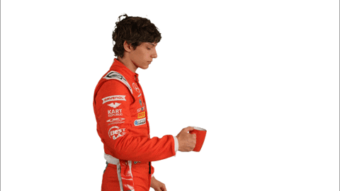 Man in Red Racing Suit Drinking from Red Container