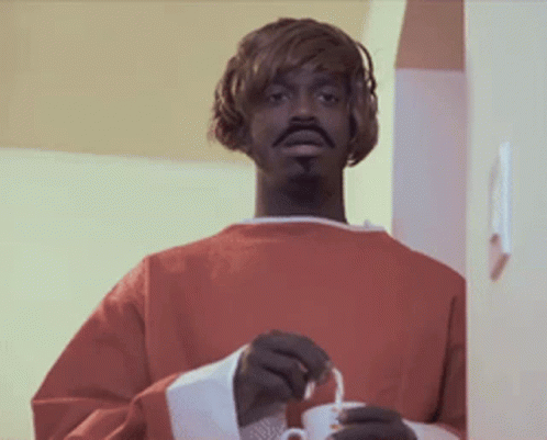 Man in Red Robe Holding White Cup