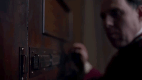 Man In Red Robe Opening Door With Latch GIF