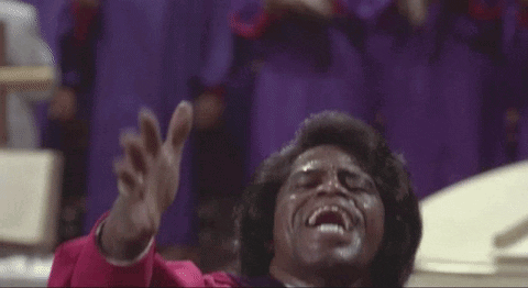 Man in Red Robe Singing Into Microphone