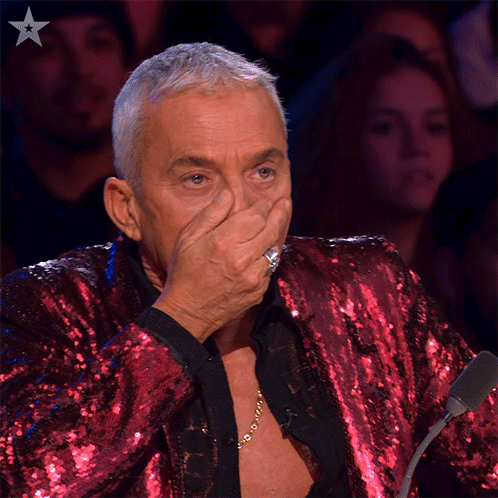 Man in Red Sequined Jacket Covering Mouth