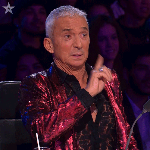 Man in Red Sequined Jacket Sitting Before Crowd