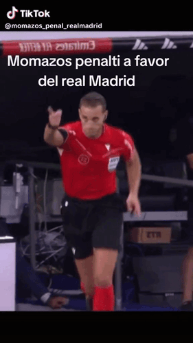 Man in Red Shirt and Black Shorts Pointing at Camera