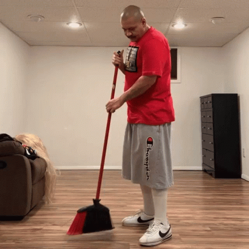 Man in Red Shirt and Gray Shorts Sweeping
