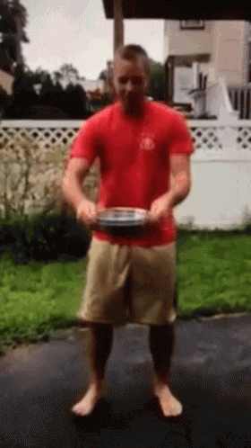 Man in Red Shirt and Tan Shorts Holding Plate