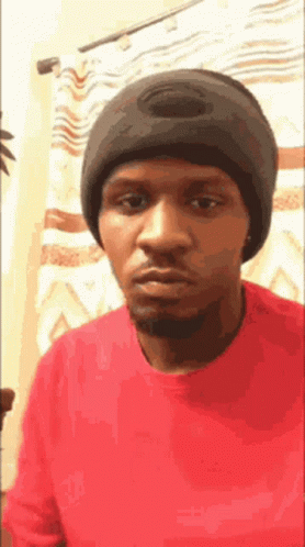 Man in Red Shirt Black Beanie Looking Camera