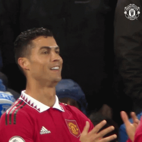Man in Red Shirt Clapping in Stadium