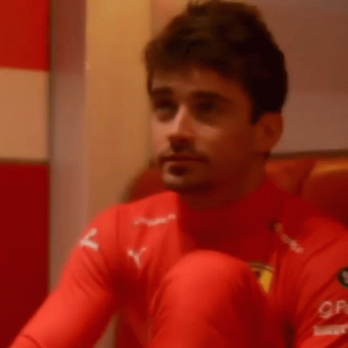 Man in Red Shirt Covering Mouth