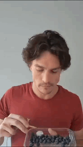 Man in Red Shirt Eating Blueberries
