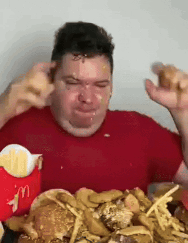 Man in Red Shirt Eating Hamburger and Fries