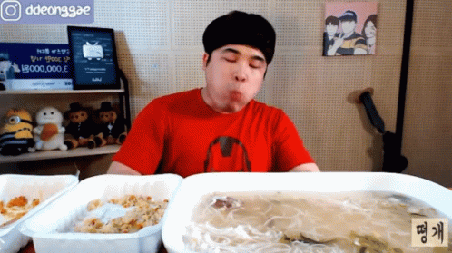 Man In Red Shirt Eating Meal With Ddeonggae Sign GIF