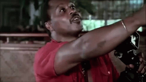 Man in Red Shirt Holding Camera Over Head