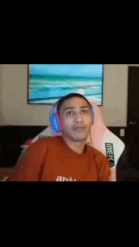 Man In Red Shirt Holding Head In Front Of TV GIF