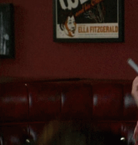 Man in Red Shirt Holding Knife in Mouth