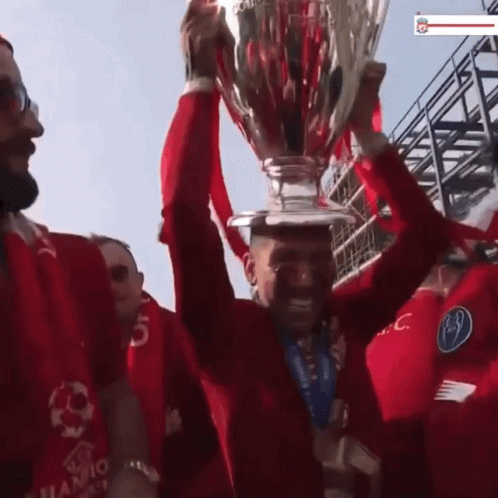Man in Red Shirt Holding Trophy