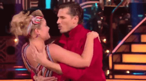 Man in Red Shirt Hugging Woman in Striped Dress
