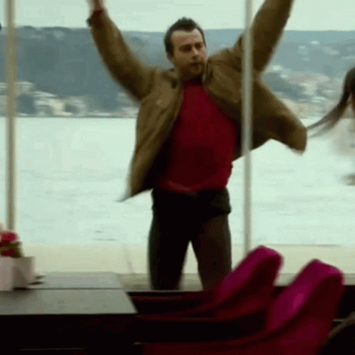 Man in Red Shirt Jumping Arms Out