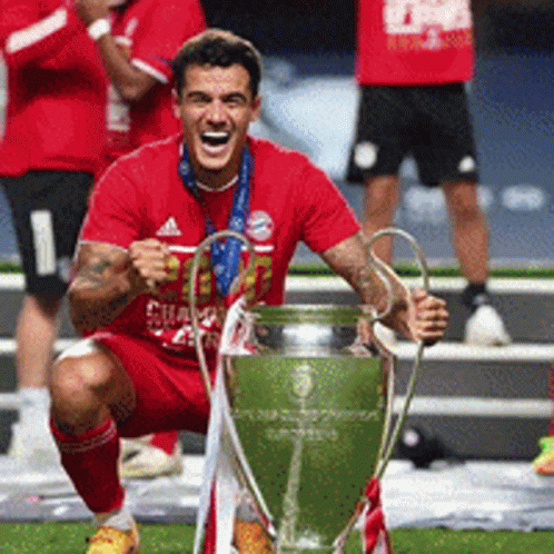 Man in Red Shirt Kneeling with Trophy