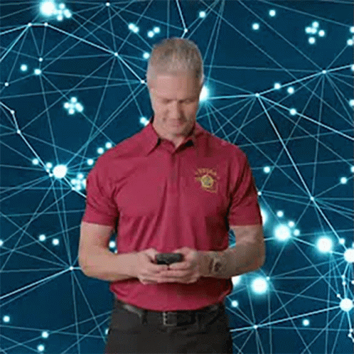 Man in Red Shirt Looking at Phone