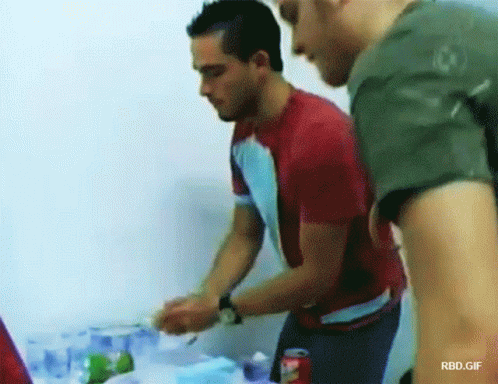 Man in Red Shirt Next to Man in Green Shirt With Coca Cola