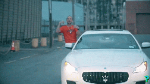 Man in Red Shirt Next to White Maserati